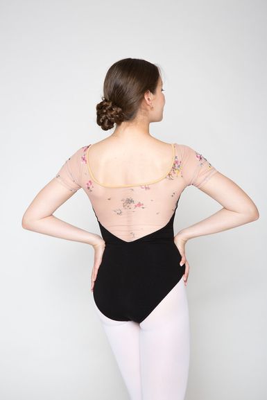 Eine Balletttänzerin in einem Ballett-Outfit mit geblümtem Oberteil