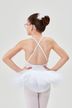 Ein junges Mädchen in einem weißen Ballett-Outfit  steht mit den Händen in den Hüften und dem Rücken zu ihr. 2