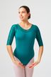 Eine Frau in einem blaugrünen Trikot mit Spitzenärmeln steht in einer Ballettpose.