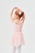 Ein junges Mädchen in einem rosa Ballett-Outfit steht mit erhobenen Armen 2