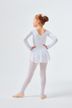 Ein junges Mädchen in einem weißen Ballett-Outfit steht mit den Händen in den Hüften und blickt abgewandt. 4