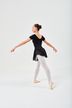 Eine Balletttänzerin in einem schwarzen Ballettbody und weißen Strumpfhosen posiert auf Spitze. 4
