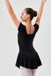 Eine junge Balletttänzerin in einem schwarzen Ballettbody und Rock steht mit erhobenen Armen da und blickt von der Kamera weg. 2