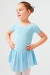 Ein junges Mädchen in einem hellblauen Ballettbody und Rock steht mit den Händen in den Hüften und schaut zur Seite. 1