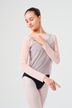 Junge Frau im Ballett-Outfit posiert mit einer Hand auf der Schulter.