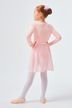 Ein junges Mädchen in einem rosa Ballett-Outfit steht mit den Händen in den Hüften und blickt von der Kamera weg. 11