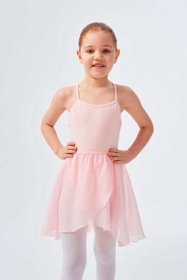 Ein kleines Kind in einem rosa Ballettkleid und weißen Strumpfhosen steht mit den Händen in den Hüften.