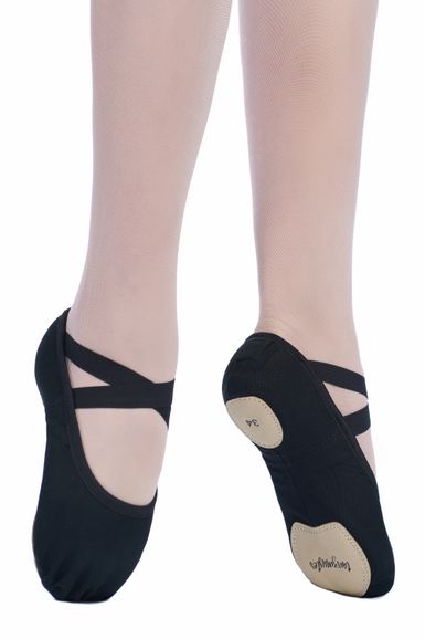 Nahaufnahme der Füße einer Tänzerin in rosa Strumpfhosen und schwarzen Ballettschuhen mit überkreuzten Riemen und Wildledersohlen.