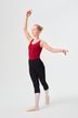 Eine junge Balletttänzerin in einem roten Trikot und schwarzen Leggings posiert mit einem erhobenen Arm und einem nach hinten ausgestreckten Bein.