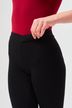 Person mit rotem Oberteil und hoch taillierter schwarzer Hose