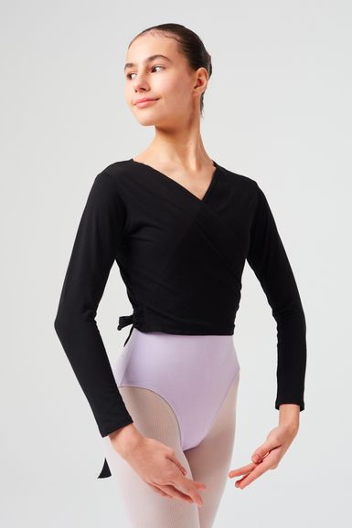 Eine Balletttänzerin in einem schwarzen Wickeloberteil und einem lavendelfarbenen Ballettbody posiert.