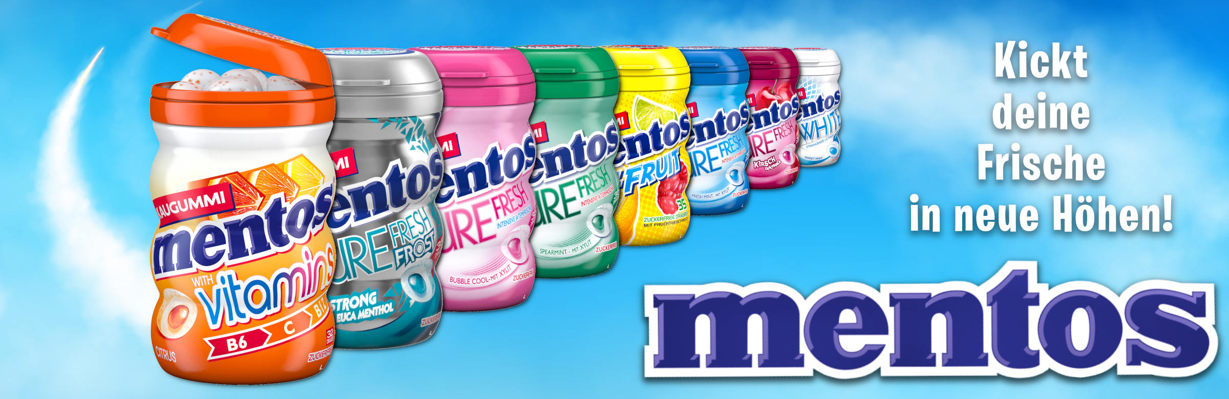 Mentos Kaugummis Mentos Kaugummis vor einem blauen Wolkenhimmel. Im Vordergrund steht eine geöffnete orangefarbene Großpackung „Mentos Vitamins“, gefolgt von einer Reihe weiterer Kaugummidosen in verschiedenen Farben und Geschmacksrichtungen. Rechts daneben stehen der Werbeslogan „Kickt deine Frische in neue Höhen!“ sowie der Mentos-Schriftzug.