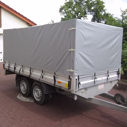 Praxisbeispiel einer grauen Hochplane auf einem zweiachsigen PKW-Anhänger aus LKW-Plane. Praxisbeispiel einer grauen Hochplane auf einem zweiachsigen PKW-Anhänger aus LKW-Plane.