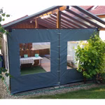 Praxisbeispiel einer grauen PVC-Seitenplane mit Sichtfenstern an einer offenen Holzüberdachung als Wind- und Wetterschutz. Praxisbeispiel einer grauen PVC-Seitenplane mit Sichtfenstern an einer offenen Holzüberdachung als Wind- und Wetterschutz.