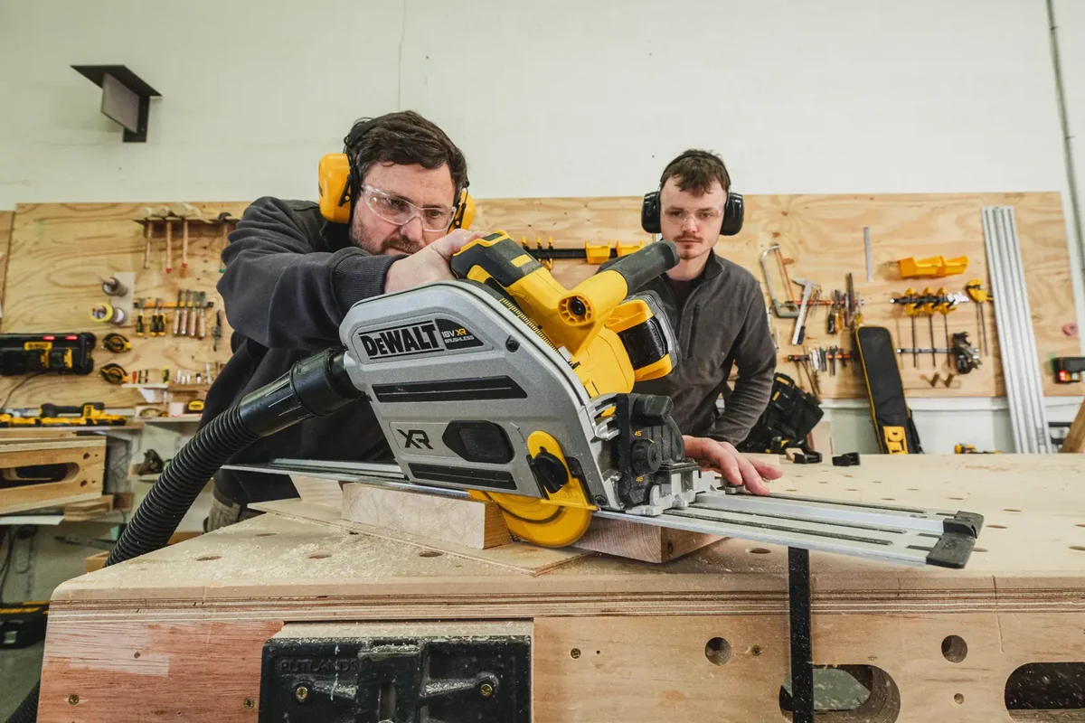 Zwei Handwerker beim Längsschnitt mit der DEWALT DCS525 auf der Führungsschiene