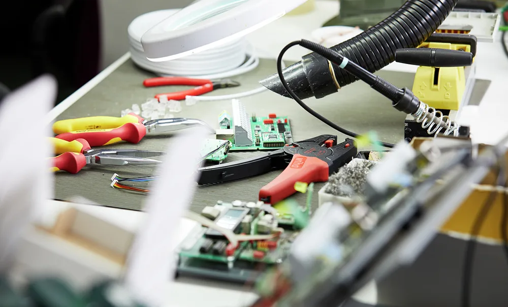 Werkbank mit Platinen, Kabeln und Wiha electric Zangen bei der Verdrahtung
