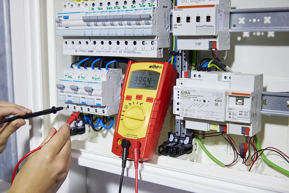 Wiha Digitalmultimeter mit Messleitungen bei der Messung im Verteilerschrank