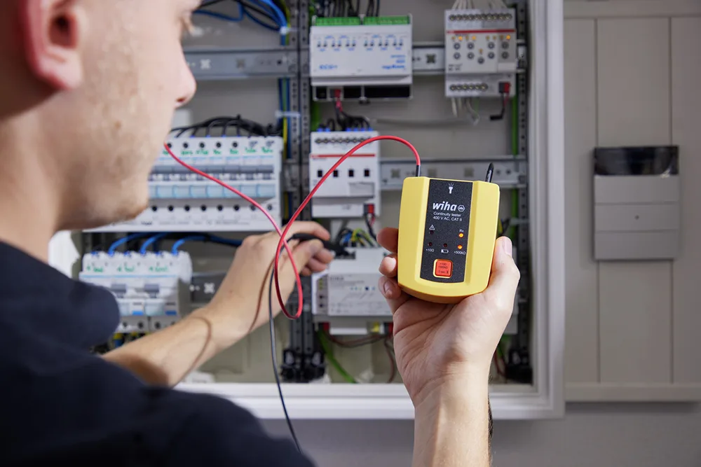 Elektriker prüft mit dem Wiha Durchgangsprüfer die Verdrahtung im Verteilerschrank