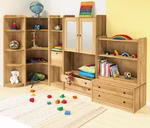 Das Livipur Carlo Schubladenelement breit ordnet bunte Bücher Spielzeug ein Regenbogenpuzzle und Kissen in einem Kinderzimmer. Kuscheltiere und verstreute Bauklötze liegen auf dem Boden neben einem hellen Vorleger.