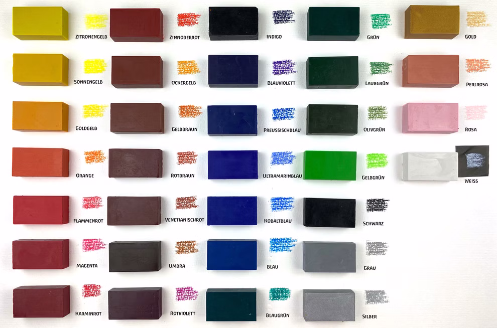 Der Stockmar Wachsmalblöcke Wachsmalblock in 32 Farben von Stockmar zeigt ein Raster aus pastellfarbenen Blöcken - gelb rot blau grün braun grau schwarz weiß rosa orange silber - mit deutschen Namen und passenden Mustern für jeden Farbton. weiß