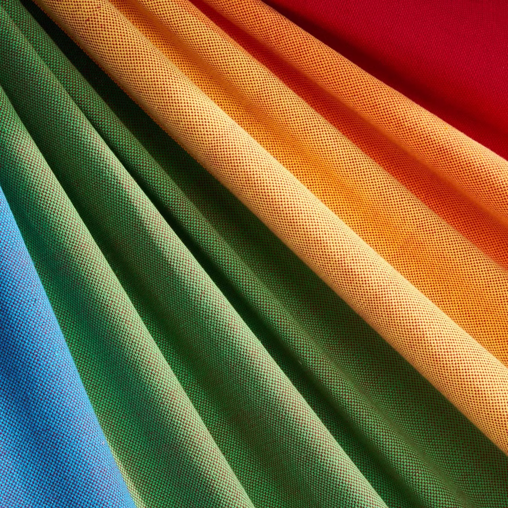 HängemattenGlück Kinderhängematte Cabrita bis 80 kg_31512 regenbogen Eine Nahaufnahme der Kinderhängematte Cabrita von HängemattenGlück. Sie zeigt ein strukturiertes netzartiges Gewebe aus leuchtend blauen grünen gelben orangen und roten Bahnen die parallel zueinander drapiert sind. Hält bis zu 80 kg. regenbogen