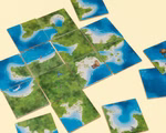 Mehrere Legespiel - Palavan Plättchen von Steffen Spiele sind mit blauem Meer grünem Land und Sandstränden zu einem kartenähnlichen Puzzle angeordnet wobei einige Plättchen von der Hauptgruppe getrennt sind.