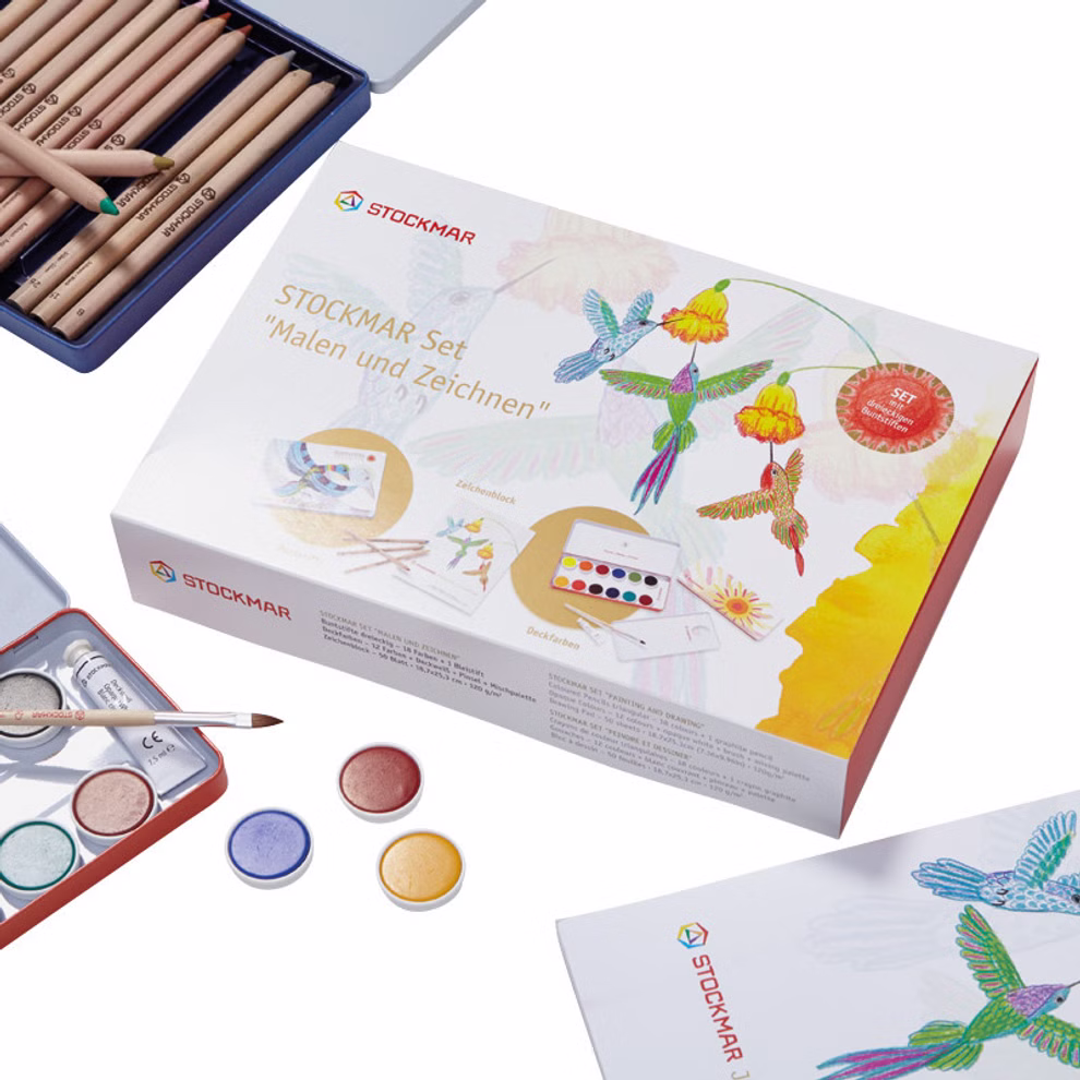 Stockmar STOCKMAR Set „Malen und Zeichnen“ mit sechseckige Stiften Geschenkte mit sechseckige Stiften_23920 Das STOCKMAR Set "Malen und Zeichnen" mit sechseckigen Stiften von Stockmar ist mit Buntstiften Aquarellfarben und Pinseln abgebildet umgeben von Kolibri und Blumenillustrationen sowie sichtbarem Malzubehör rund um die Schachtel.