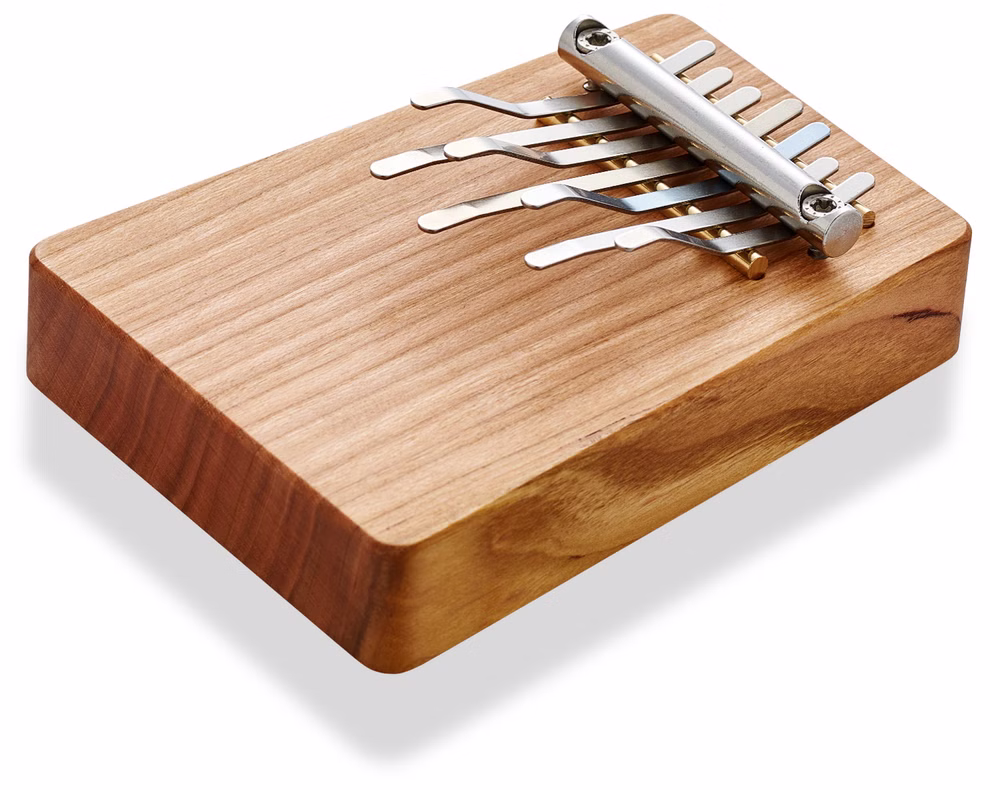 Hokema Waldorf Kalimba G-pentatonisch 432 Hz_16732 Die Hokema Waldorf Kalimba G-pentatonisch 432 Hz ist ein hölzernes Daumenklavier mit sieben in einer Reihe angeordneten Metallzinken auf weißem Hintergrund.
