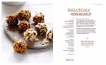 Löwenzahn Verlag Die besten Weihnachtskekse 111 Rezepte_16590 Auf einer weißen Fläche steht ein Teller mit Schokoladen- und Nougat-Trüffeln mit Nussüberzug. Daneben liegt eine Seite aus dem Buch "Die besten Weihnachtskekse 111 Rezepte" des Löwenzahn Verlags mit Anleitungen für Nougatkugeln und Mokkakugeln in deutsche