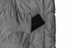 Schlafsack mit Almwolle Ein Schlafsack mit Almwolle von Grüezi bag passend für Körpergrößen bis 185 cm liegt teilweise im geöffneten grauen Packsack vor weißem Hintergrund.