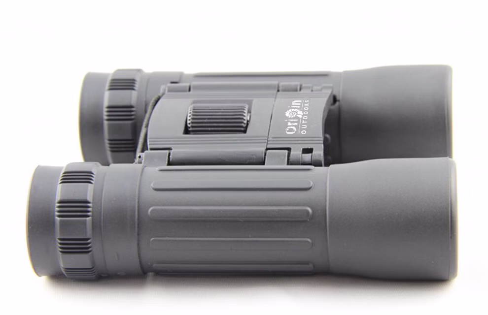 Origin Outdoors Fernglas 10-fache Vergrößerung_18197 Ein Paar schwarze kompakte Origin Outdoors Fernglas 10-fache Vergrößerung Fernglas mit strukturierten Griffen und einem zentralen Fokus Rad auf einer weißen Oberfläche gezeigt. Der Markenname ist in der Nähe der Mitte Scharnier sichtbar.