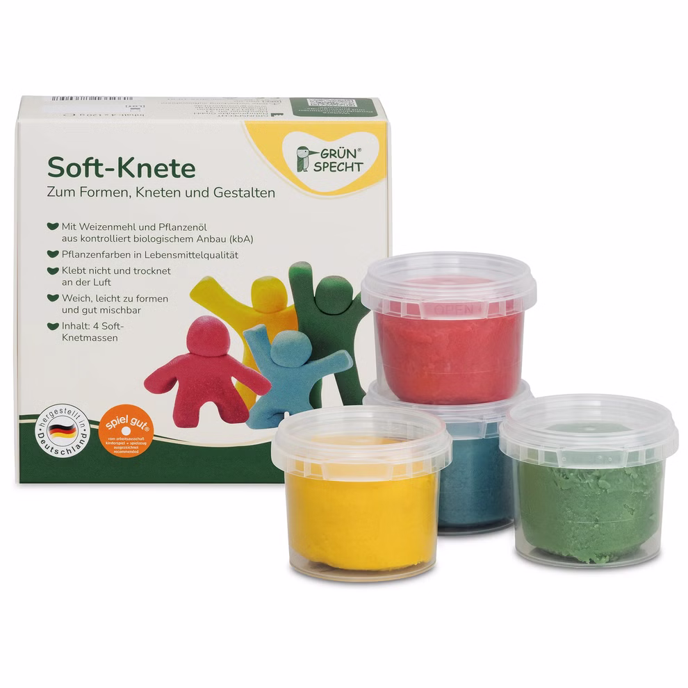 Soft-Knete Vier Dosen GRÜNSPECHT Soft-Knete in Blau, Gelb, Grün und Rot vor der Pappverpackung, zum Formen und Mischen ab 2 Jahren.