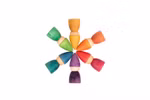 Grapat Holzspielzeug Regenbogen Zwerge von Grapat zeigt acht bunte Holzpuppen in einem Regenbogen von Farben angeordnet in einem Kreis auf einem weißen Hintergrund.