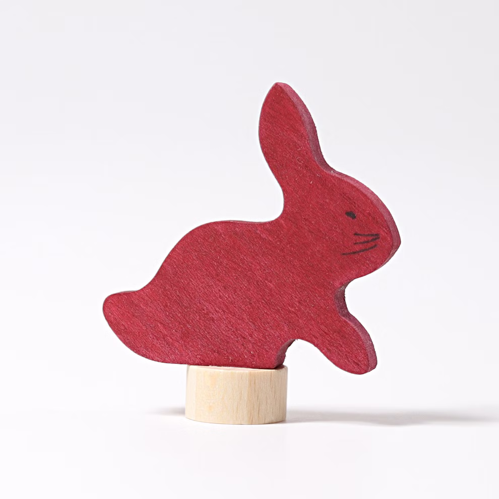 Grimm's Grimm`s Steckfigur Hase _19795 Die Grimm'sche Steckfigur Hase ist ein roter Holzhase mit einfachen Gesichtszügen der aufrecht auf einem kleinen zylindrischen Holzsockel vor einem schlichten weißen Hintergrund steht.