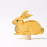 Grimm's Grimm`s Steckfigur Hase sitzend _19853 Die Grimm's Steckfigur Hase sitzend ist eine Holzfigur eines gelben Hasen mit gemalten Details der aufrecht auf einem kleinen zylindrischen Sockel sitzt. Sie wurde von Grimm's hergestellt und ist vor einem schlichten weißen Hintergrund abgebildet.