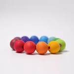 Der Grimm's Regenbogen Perlenring ist ein 9 cm langes rundes Armband mit 2 cm großen Holzperlen in den Farben Rot Orange Gelb Grün Blau und Violett die vor einem schlichten weißen Hintergrund stehen.