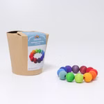 Grimm's Regenbogen Perlenring Ø 9 cm von Grimm's ist neben der braunen Papierverpackung mit einem blauen Etikett abgebildet auf dem die Abbildung und Beschreibung des Spielzeugs zu sehen ist. Die Holzperlen (Ø 2 cm) sind in einem leuchtenden Regenbogenverl