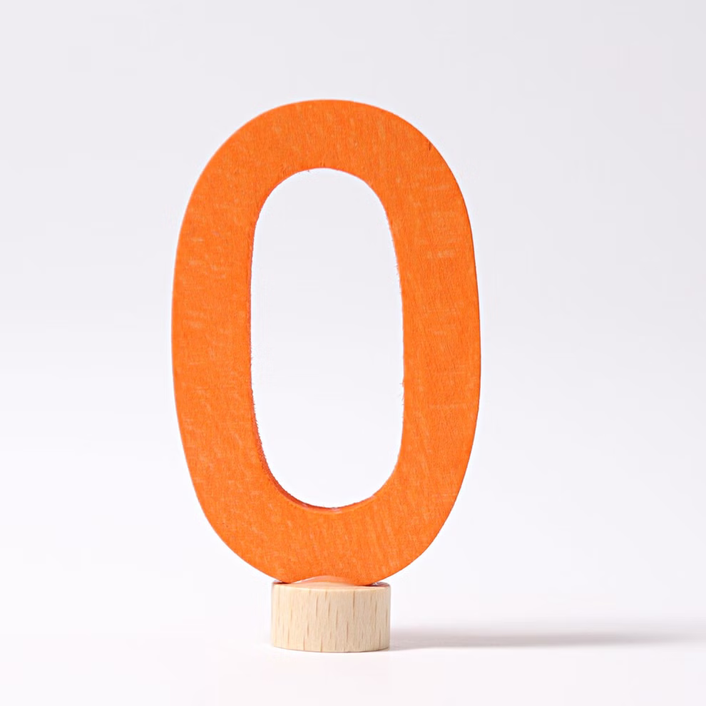Eine große orangefarbene hölzerne Zahl Null aus Grimms Geburtstagsstecker Zahlen by Grimm's steht aufrecht auf einem kleinen runden Holzsockel vor einem schlichten weißen Hintergrund. 0