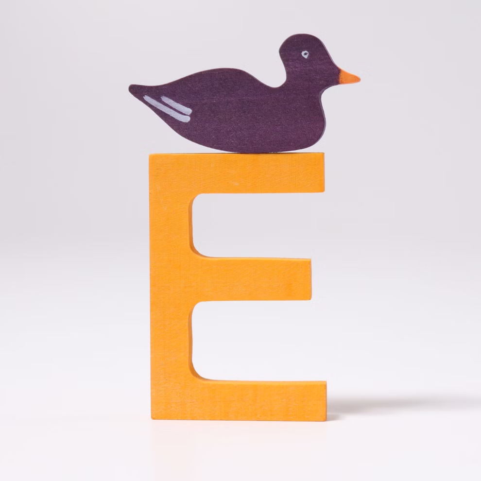 Grimm's Grimm's Buchstaben aus Holz A-Z_22812 E Eine lila Ente sitzt auf dem großen gelben Holzbuchstaben E von Grimm's Buchstaben aus Holz A-Z der vor einem schlichten weißen Hintergrund steht. E