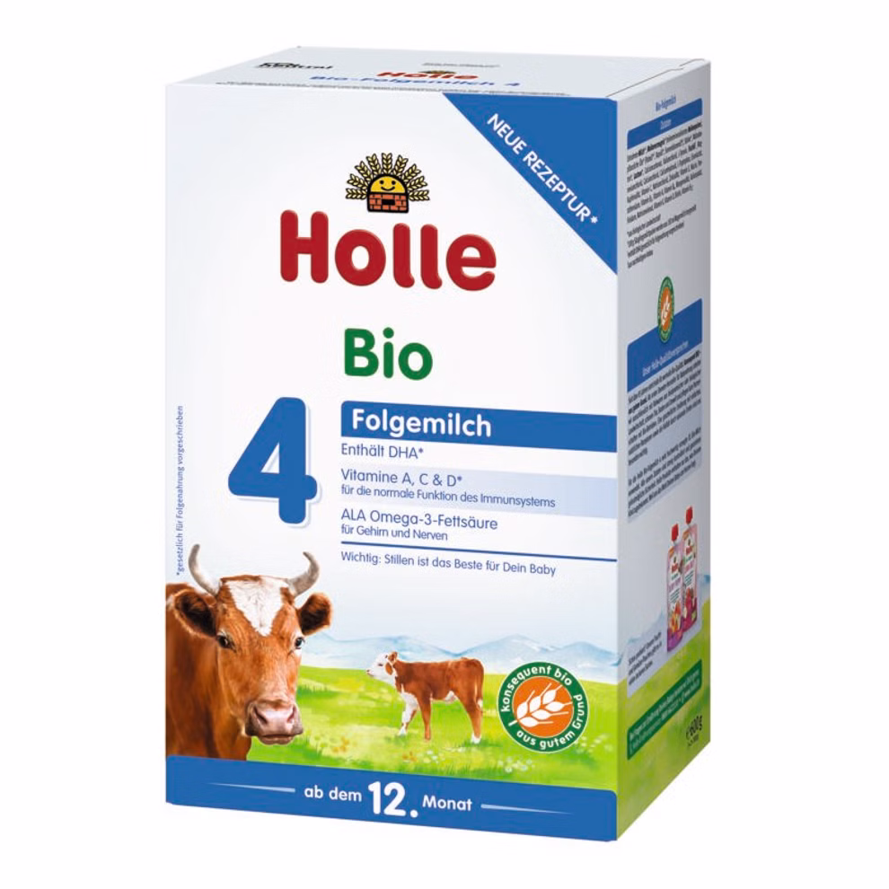 Holle Bio-Folgemilch 4 ab dem 12. Monat_21158 Eine Schachtel Holle Bio-Folgemilch 4 ab dem 12. Monat für Babys ab 12 Monaten mit überwiegend weißer Verpackung mit blauen und grünen Akzenten einer Kuh auf einem Feld und Nährwertangaben auf der Vorderseite.