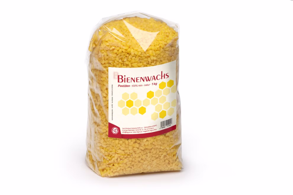 Karl Schubert Gemeinschaft Bienenwachs Pastillen 1 kg _20727 Ein durchsichtiger Plastikbeutel der 1 kg kleine gelbe Bienenwachs-Pastillen der Karl Schubert Gemeinschaft enthält mit einem gelben deutschen Etikett mit Produktangaben.
