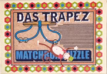 Eine verspielte Illustration zeigt einen Cartoon-Affen der kopfüber an Turnringen hängt mit "DAS TRAPEZ" oben und "Puzzle in einer Streichholzschachtel" vom moses. Verlag am unteren Rand umrahmt von einer bunten geometrischen Bordüre.