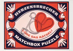 Ein Etikett im Vintage-Stil auf moses. Das Puzzle in einer Streichholzschachtel des Verlags zeigt Herzen Hände und ein Metallpuzzle. "Löse das Rätsel!" steht in roter Schrift neben zwei ineinandergreifenden Herzen.