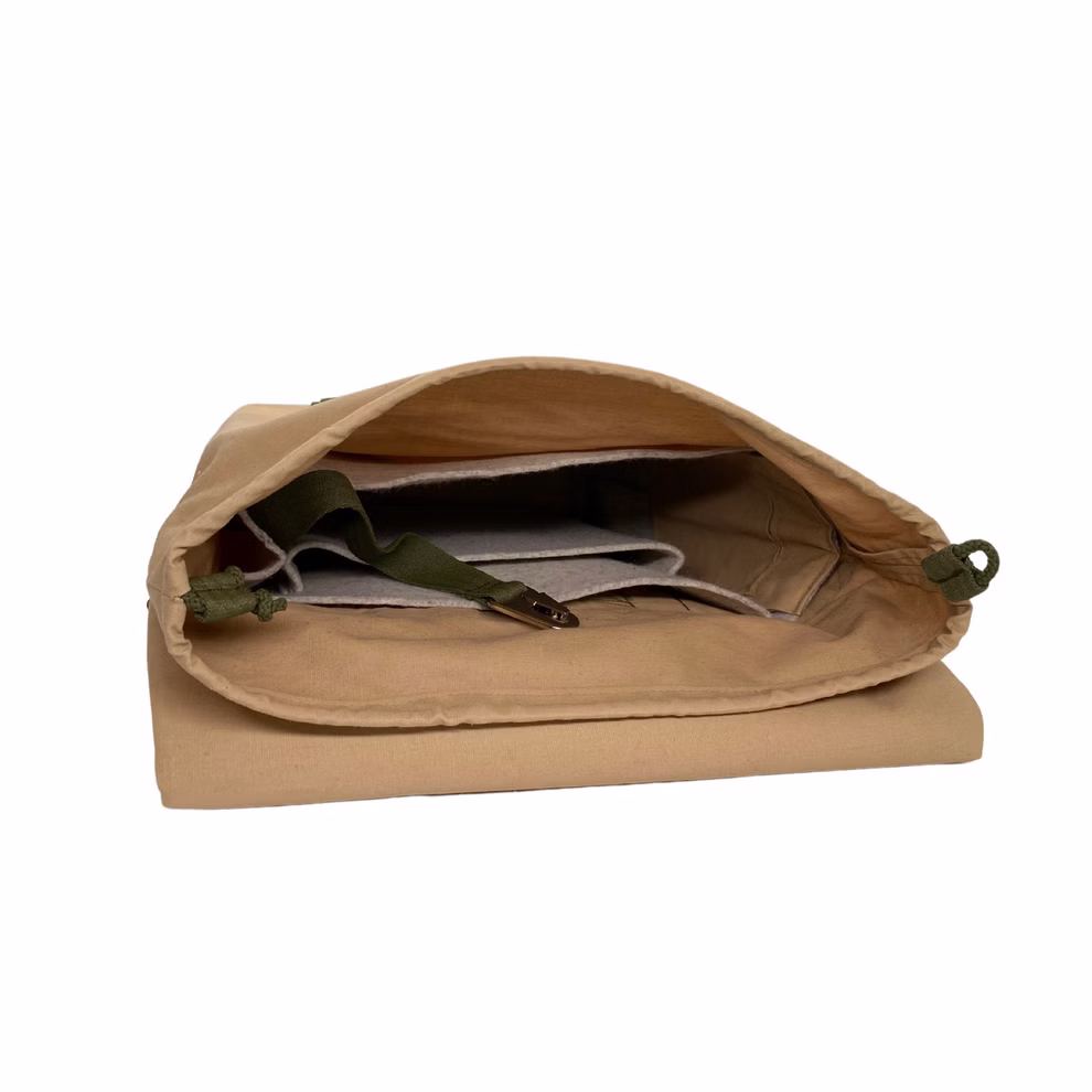 SuperRanzen Rolltop Rucksack sand-olive modulares Design_22446 Der SuperRanzen Rolltop Rucksack in Sand-Olive verfügt über ein modulares Design Innenfächer einen grünen verstellbaren Gurt und mehrere Taschen zur Organisation. Leer mit geöffneter Klappe vor weißem Hintergrund abgebildet.