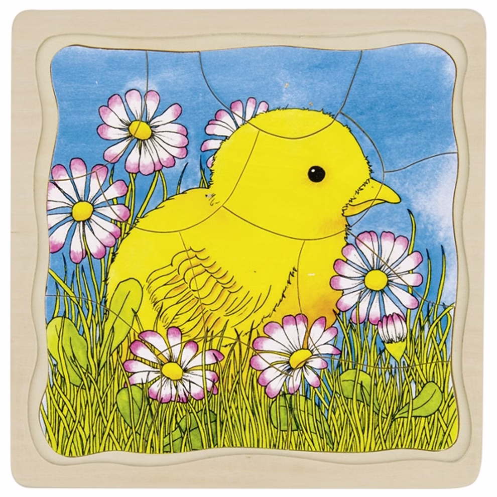 Goki Schichtenpuzzle Das Huhn _23567 Das Goki Schichtenpuzzle Das Huhn zeigt ein gelbes Küken inmitten von grünem Gras und weiß-rosa Gänseblümchen vor einem blauen Himmel.