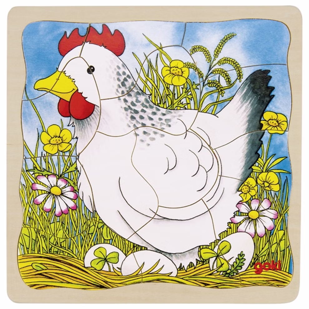 Goki Schichtenpuzzle Das Huhn _23568 Das Goki Schichtenpuzzle Das Huhn zeigt eine farbenfrohe Illustration einer weißen Henne im Gras umgeben von gelben und weißen Blumen mit drei Eiern zu ihren Füßen und einem blauen Himmel präsentiert als charmantes Holzpuzzle.