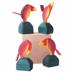 Decor Stimmungsvogel Temperamentsvogel _315 Vier farbenfrohe Decor Stimmungsvogel Temperamentsvogel Holztukanfiguren mit roten gelben und grünen Akzenten sind um einen hellen Holzblock herum angeordnet wobei jede Figur anders positioniert ist um einzigartige Winkel und Flügelstellungen hervorzuheben