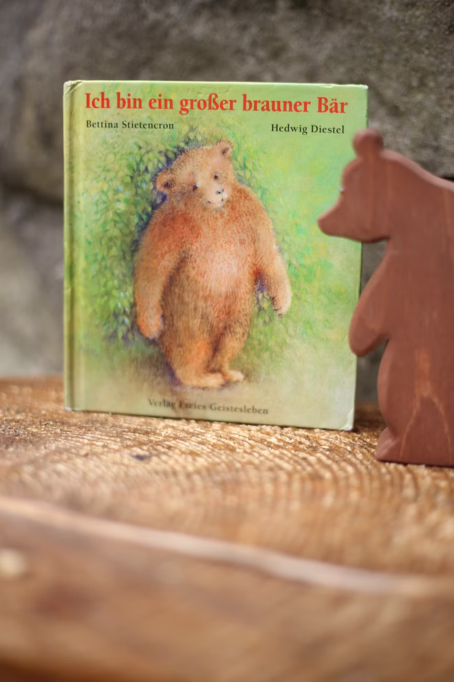 Freies Geistesleben Ich bin ein großer brauner Bär Hedwig Diestel Bettina Stietencron_2705 Das Buch "Ich bin ein großer brauner Bär" von Hedwig Diestel und Bettina Stietencron (Freies Geistesleben) steht aufrecht auf Holz neben einer kleinen bärenförmigen Figur. Auf dem Umschlag ist ein Braunbär abgebildet.