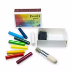 Die Seccorell Mini Box Wischen+Malen Farbstäbchen & Zubehör von Seccorell zeigt auf weißem Hintergrund bunte Pigmentstäbchen eine kleine weiße Box mit deutschem Etikett einen Mini-Pinsel mit Holzgriff und schwarzen Filz.