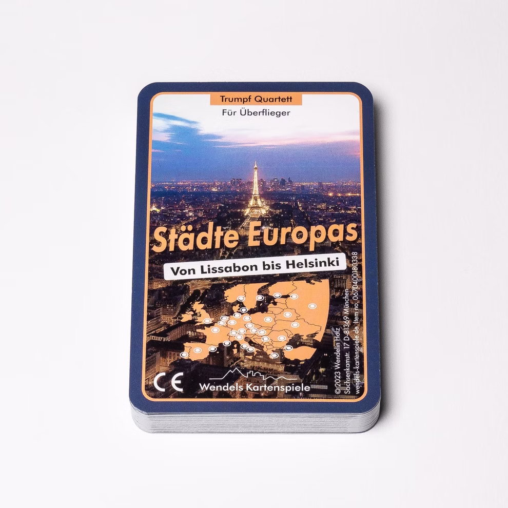 Wendelins Kartenspiele Quartett Städte Europas 32 Städte des Kontinents_25015 Das Quartett Städte Europas 32 Städte des Kontinents von Wendelins Kartenspiele zeigt ein Stadtbild mit dem Eiffelturm eine Europakarte und einen deutschen Text. Die Karten sind auf einer weißen Fläche gestapelt.